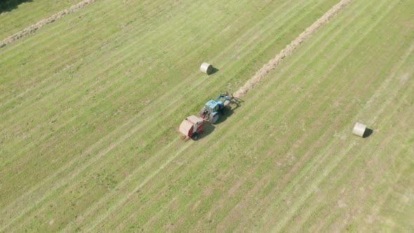Blue Tractor Hay Bales Aerial View alt