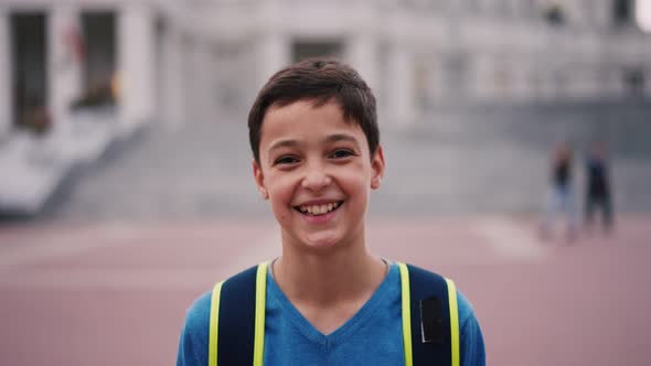 Portrait of Happy Caucasian Boy Standing in School Yard Smiling to Camera alt