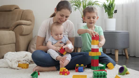 Smiling Happy Family Building High Tower with Toy Blocks and Bricks alt