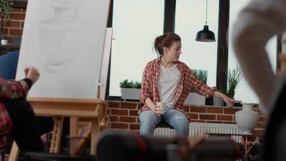 Young Woman Showing Inspiration Model to Art Students alt