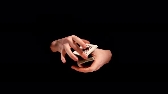 Magician Making His Trick with Cards on Black Background alt