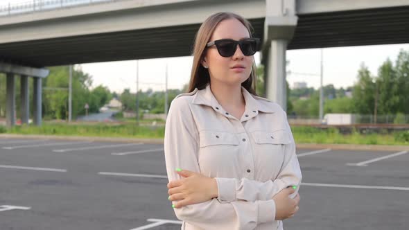 Beautiful Young Girl with Glasses Walks Through the City and Looks Around