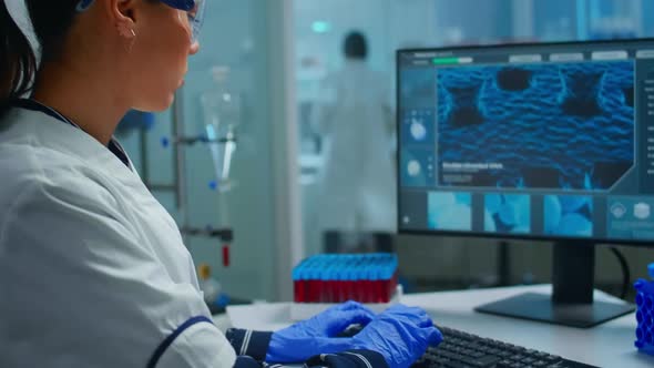 Lab Techinican Woman Sighing at Camera While Working at Pc alt