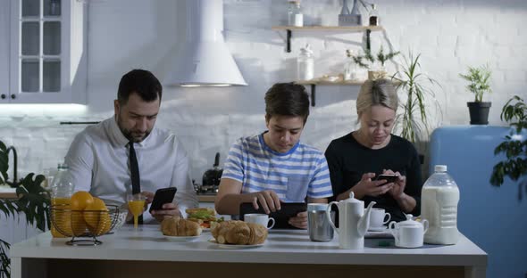 Family Sitting at the Kitchen Table alt