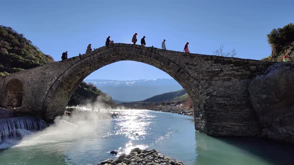 People crossing stone bridge on a winter sunny day