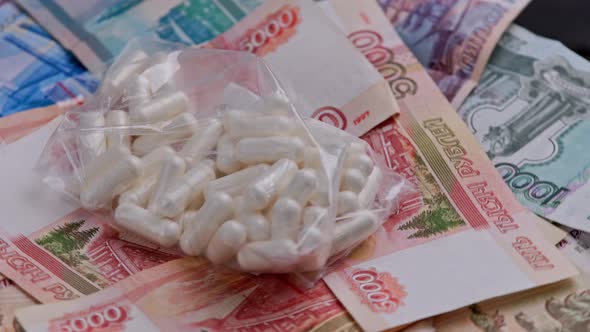 Looped Rotation of Russian Rubles Paper Banknotes and Ziplock Plastic Bag with White Capsules