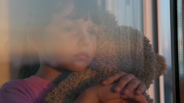 Sad child by the window.  alt