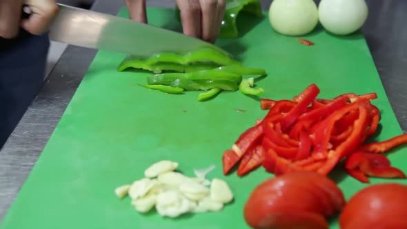 The Cook Cuts Fresh Vegetables with a Knife on the Board alt