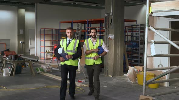 Male architect discussing at construction site