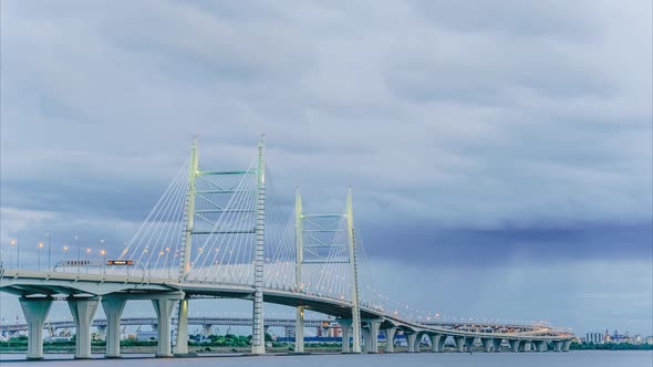 Timelapse of a Large Modern Bridge with Moving Cars in the Evening Against the Background of Rainy alt