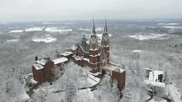 panoramic view of religious complex in forest covered in snow.