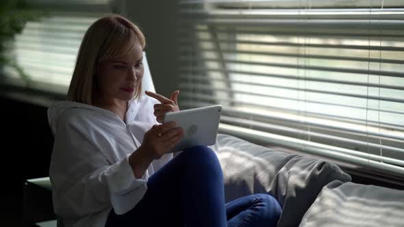 Young Woman Is Chatting Online By Internet on Tablet, Resting at Home in Weekends alt