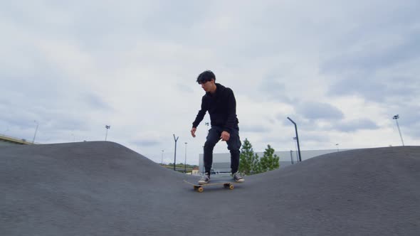 Guy Rides Skateboard on Asphalt Waves alt