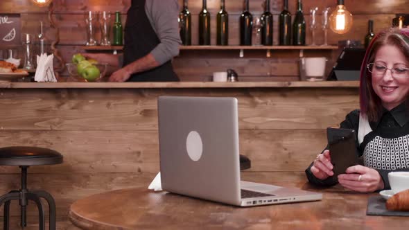 Businesswoman Drinks Coffee While Having a Video Call alt