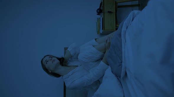 Upset Woman Sits on Bed at Late Dark Night Kneading Neck alt
