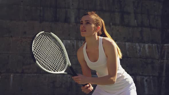 Woman playing tennis on a sunny day alt