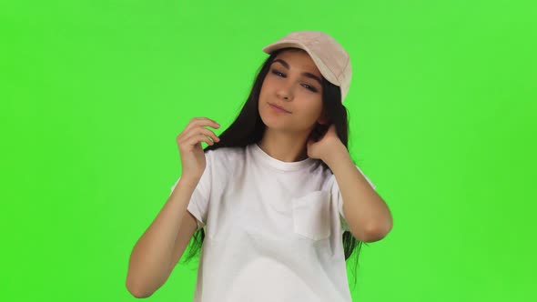 Attractive Young Stylish Woman Putting on Pink Baseball Cap alt
