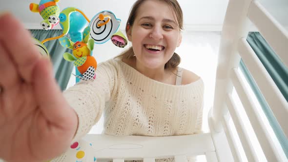 POV of Mother Gently Stroking and Caressing Her Little Baby Lying in Wooden Cradle alt