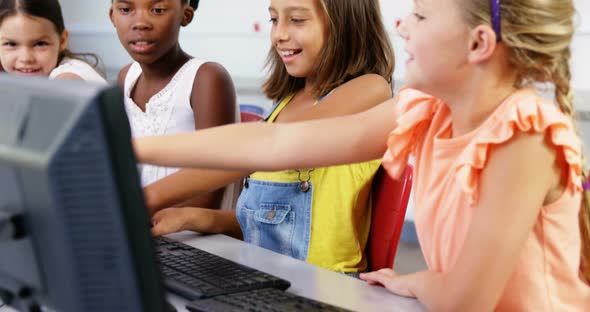 Schoolgirls using computer in classroom alt