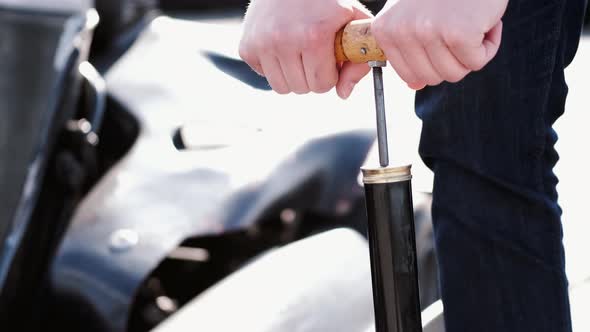 Attractive Man Checking Tire Pressure on His Gocart alt