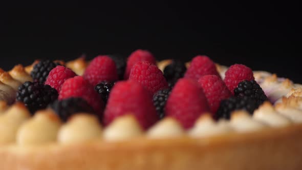 A piece of the Tasty Forest Fruit Torte twisting against a black background
