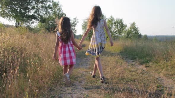 Two little girls walking on rural road