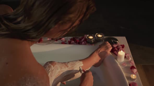 Caucasian woman shaving leg in bath in hotel alt