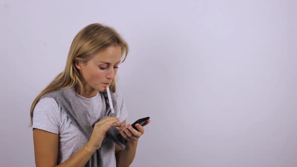 Woman Measures Temperature During Illness and Communicates on the Phone alt