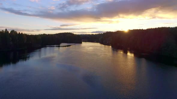Aerial video of a drone ascending to see the setting sun. Finland, June 2018. alt