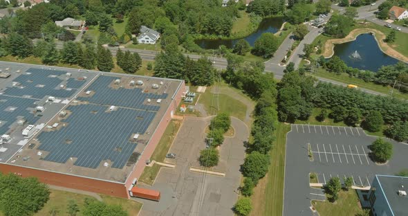Aerial Panoramic Overview of Solar System on a Roof Building Warehouse Near American Small Town alt