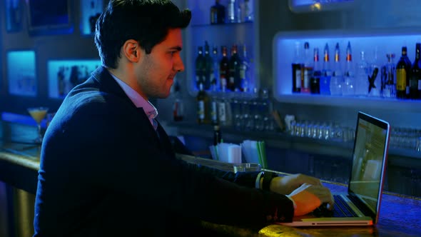 Well dressed man using a laptop at counter alt