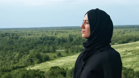 Pensive Muslim Woman in Black Headscarf Admiring Nature Landscape Breathing Freedom Closeup Slowmo alt