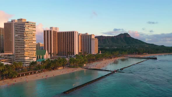 Drone Flyover Crowded Hawaiian Beach with People Relaxing in Sand And Diamond Head Tuff Cone Overloo alt