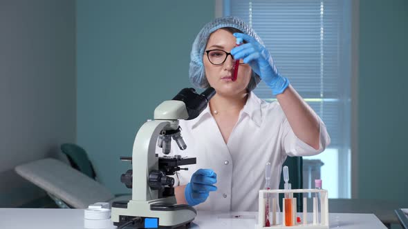 Lab Assistant Shakes Test Tube with Red Liquid in Hospital, Stock Footage