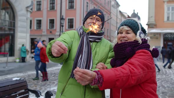 Senior Couple with Burning Sparklers Bengal Lights Celebrating Anniversary on City Center Street alt