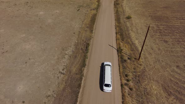 A limousine drives down a country road shot taken from drone. alt