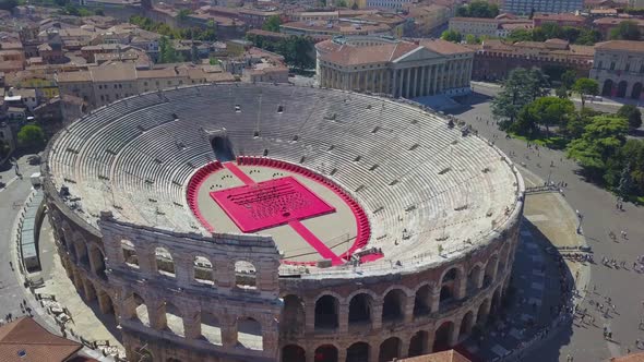 Aerial panoramic view of Arena di Verona, Italy. Drone flies from houses with scooped roofs to Arena alt