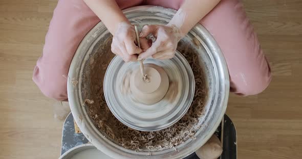 Female Potter Sitting and Makes a Cup on the Pottery Wheel. Woman Making Ceramic Item. Pottery alt