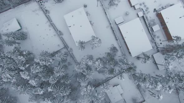 Aerial View Down to a Plot with a House in the Snow