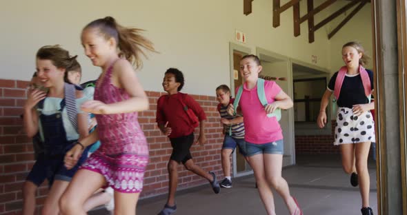 Group of kids running in the school corridor alt