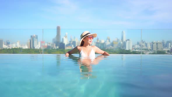 Young asian woman enjoy around outdoor swimming pool for leisure alt