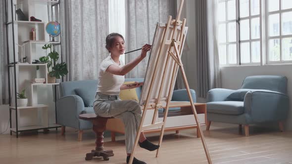 Asian Artist Girl Holding Paintbrush Mixed Colour And Thinking Before Painting On The Canvas alt