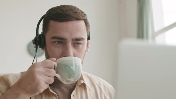 Guy with Headphones Drinking from Cup alt