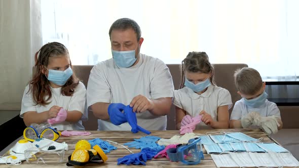 Dad Shows Children in Medical Masks How To Put on Medical Gloves. Social Distancing and Self