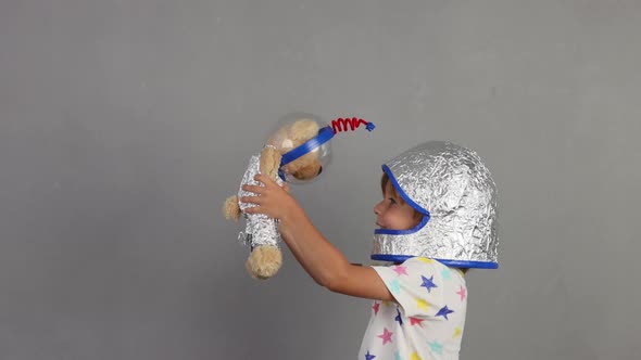 Happy child playing with teddy bear astronaut. Slow motion alt