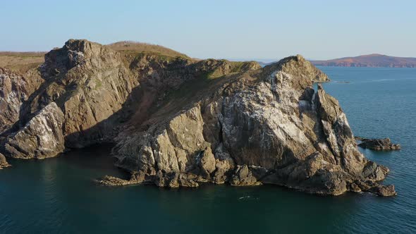 Island with High Vertical Rocks Among the Sea alt