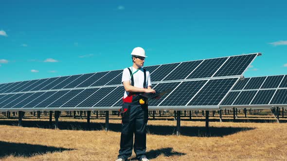 Male Expert Is Observing a Solar Electric Generating Station alt