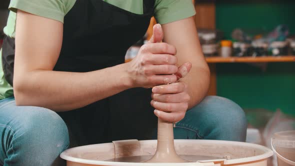 Pottery - Potter Master Is Pulling Clay in Length on a Potter's Wheel with Both Hands alt