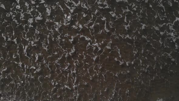 Top Down View Of Foamy Sea Waves Washing On The Shore At The Beach Near Brouwersdam, Netherlands - a alt