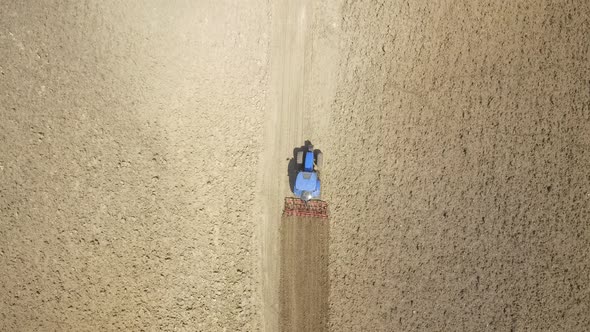 Farmer on tractor plowing a field in Umbria, Italy alt